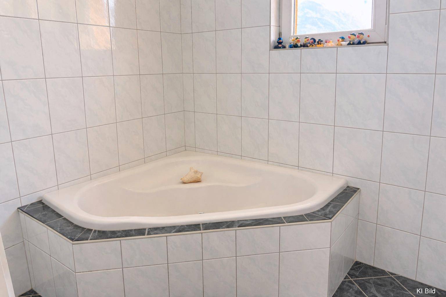 Eckbadewanne in einem hell gefliesten Badezimmer mit einem kleinen Fenster.