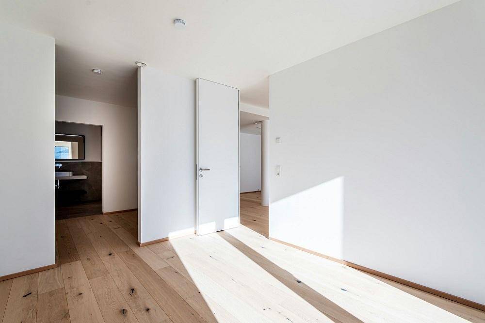 Heller Flurbereich mit Eichenparkett und Zugang zu weiteren Räumen, inklusive Badezimmer.
