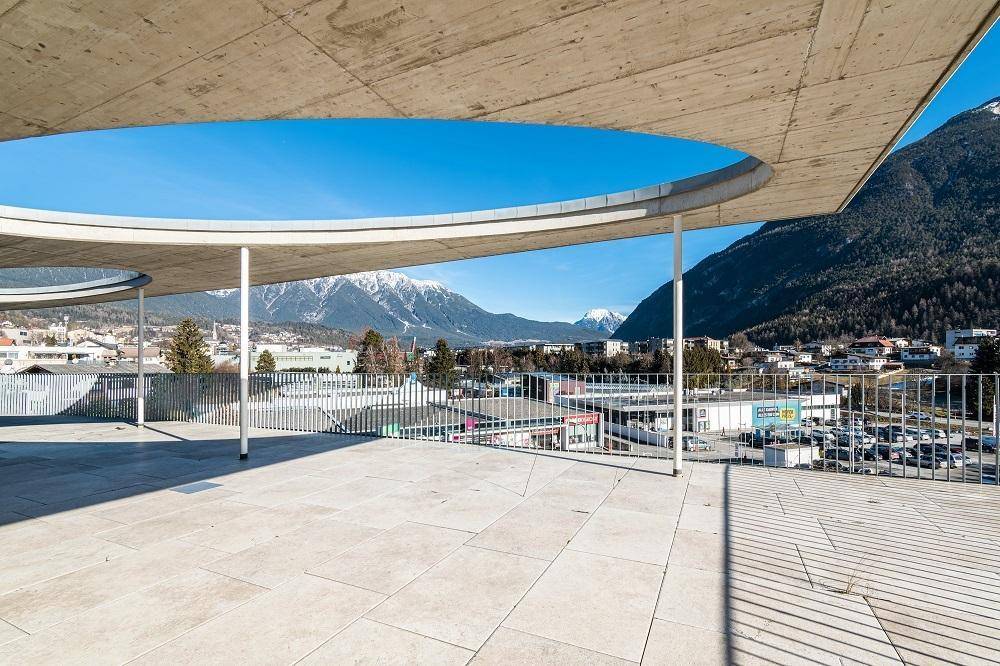 Weitläufige Terrasse mit modernen Geländern und unverbaubarem Blick auf die umliegende Bergwelt.
