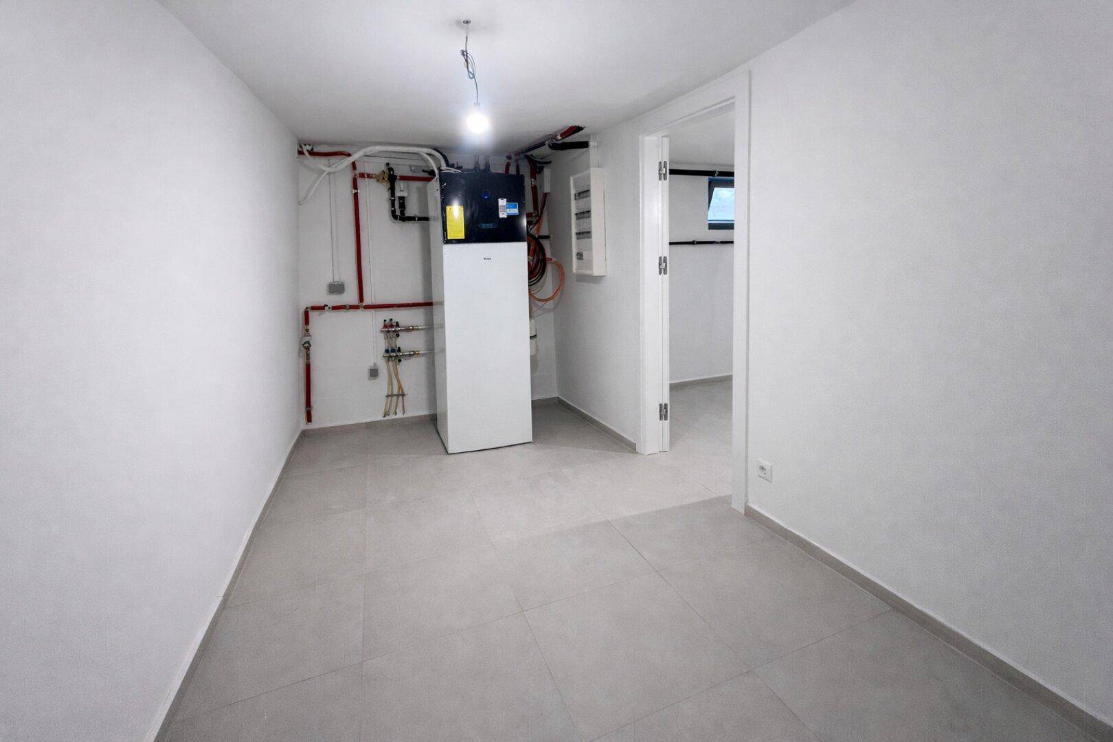 Technikraum im Keller mit moderner Heizungsanlage und Fliesenboden.
