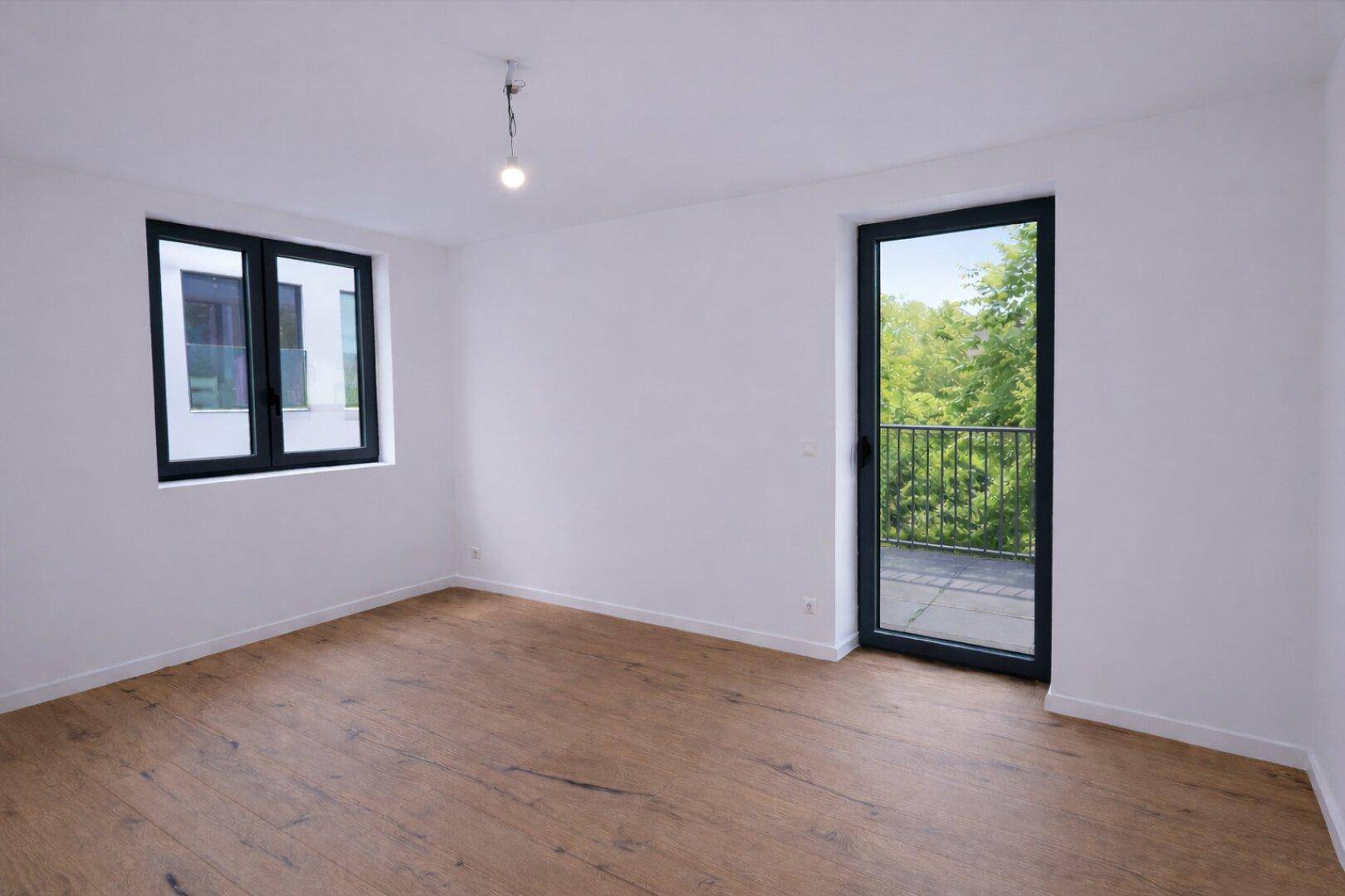 Lichtdurchflutetes Schlafzimmer mit Holzboden und Balkonzugang.