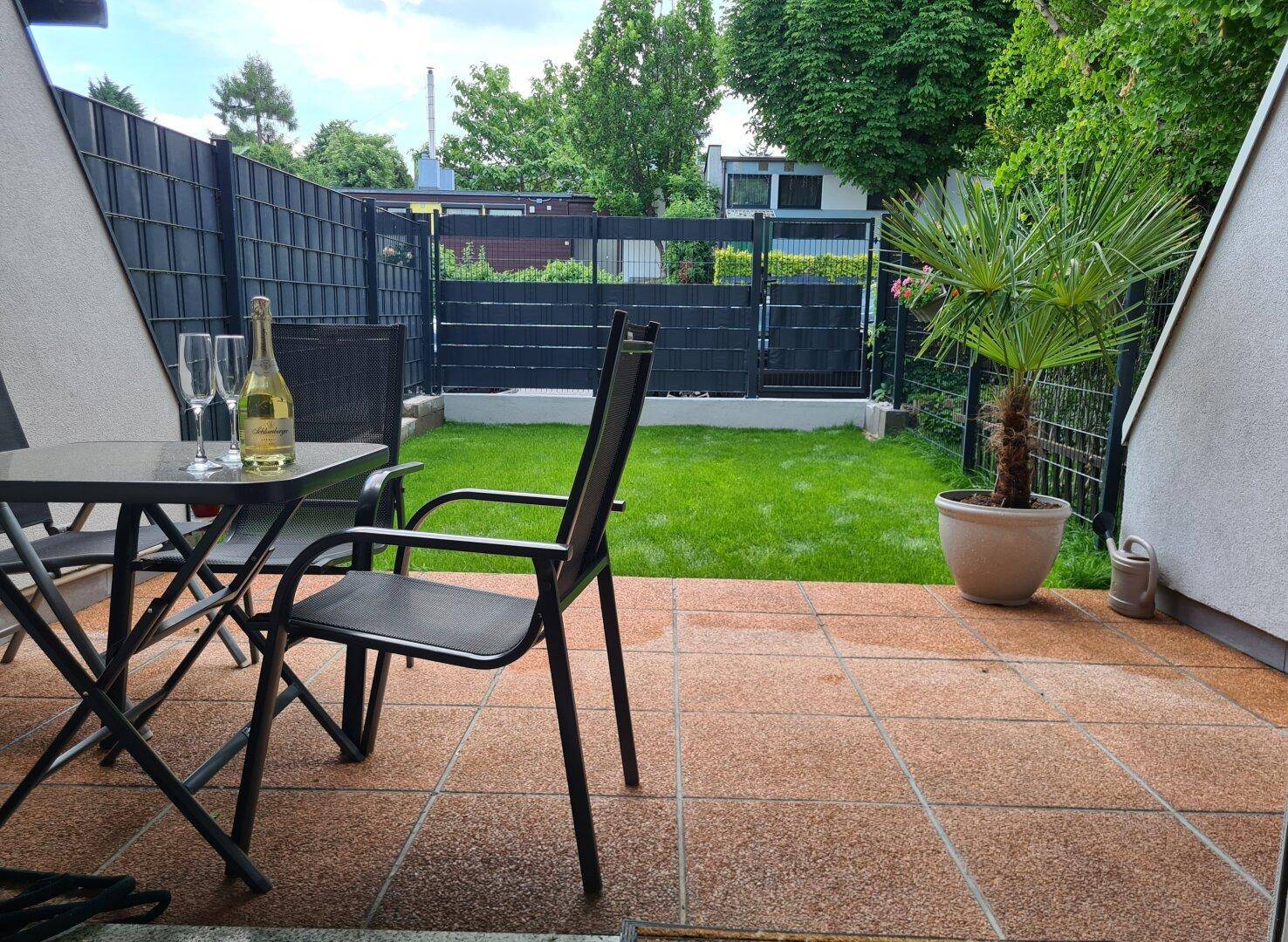 Gemütliche Terrasse mit Sitzgelegenheiten und Blick auf den gepflegten Rasenbereich, ideal für gesellige Abende.
