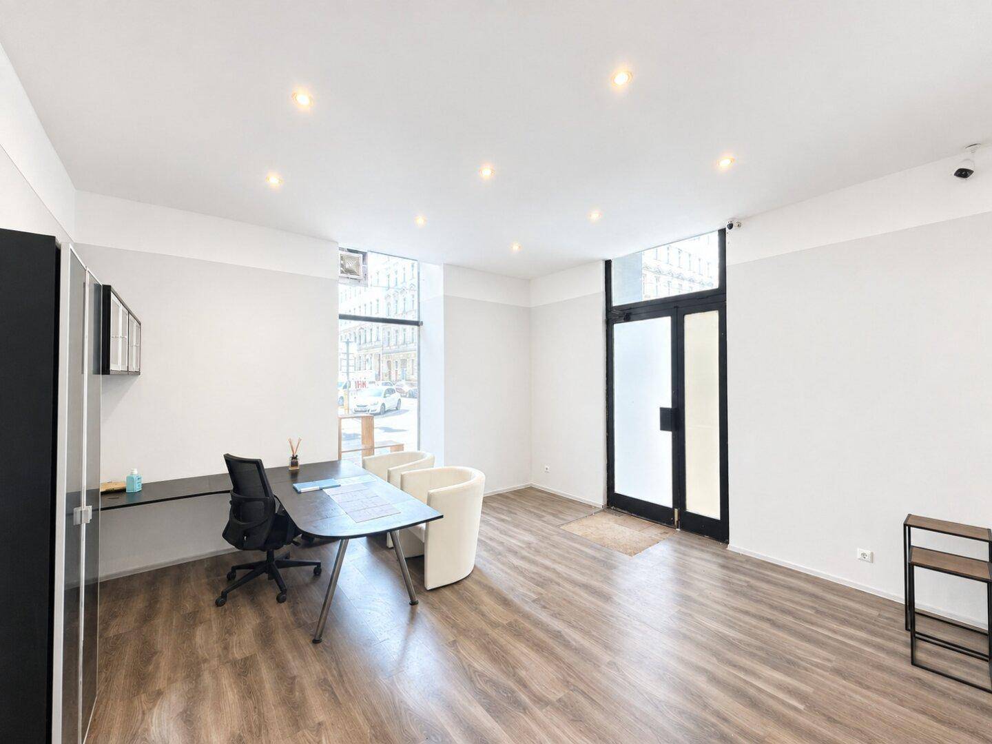 Helles Büro oder Empfangsbereich mit modernem Bodenbelag und großen Fenstern zur Straße.