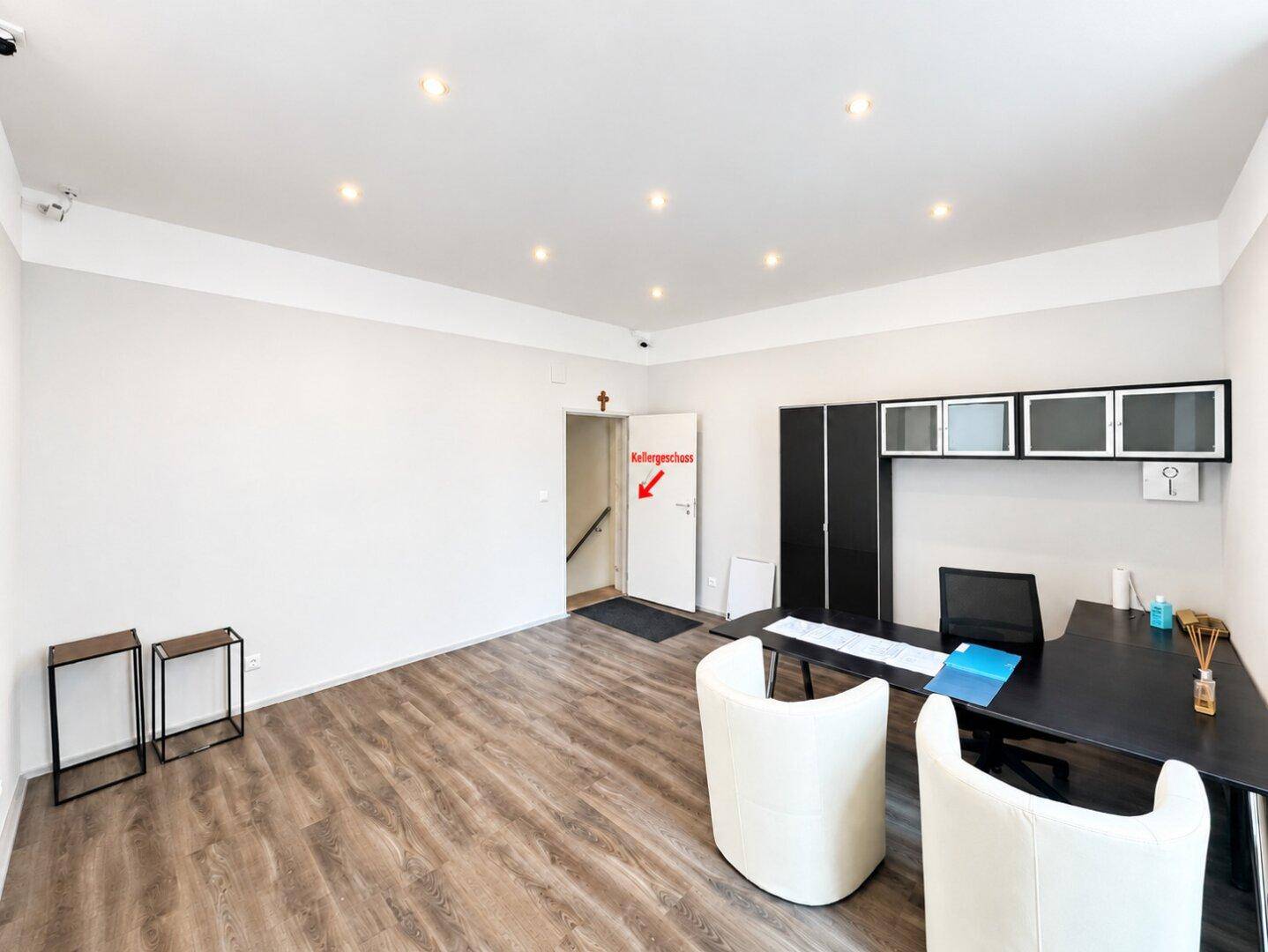 Helles und modernes Büro mit Laminatboden, Einbauschränken und direktem Zugang zum Kellergeschoss.