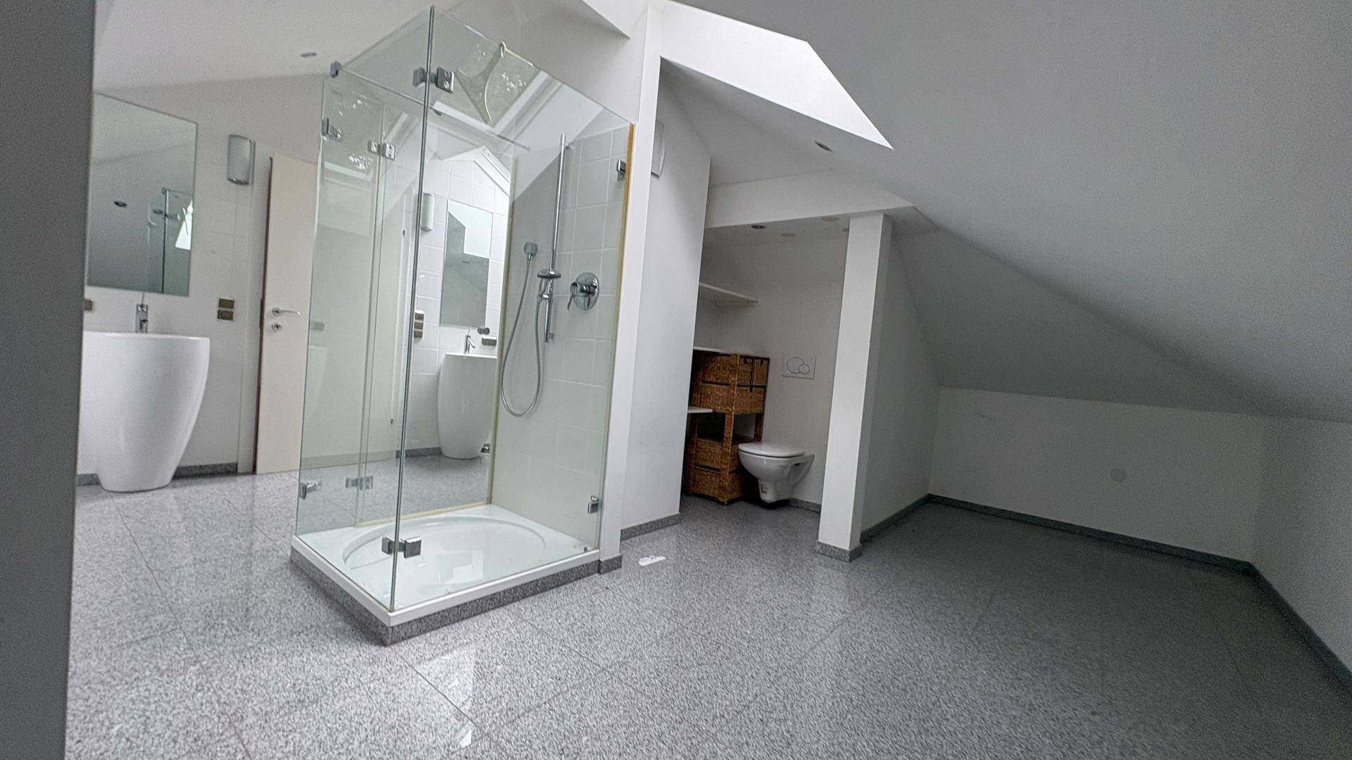 Modernes Dachgeschossbad mit Duschkabine, Doppelwaschbecken und schrägen Wänden.