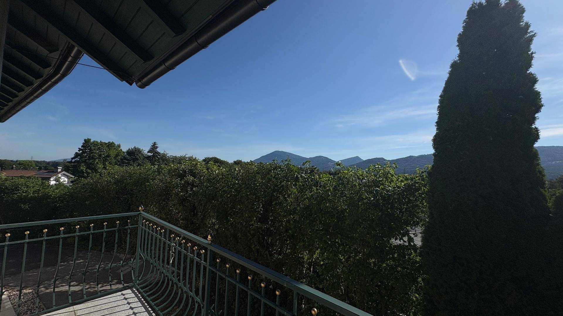Balkon mit weitem Blick auf die grünen Berge und die umliegende Naturlandschaft.
