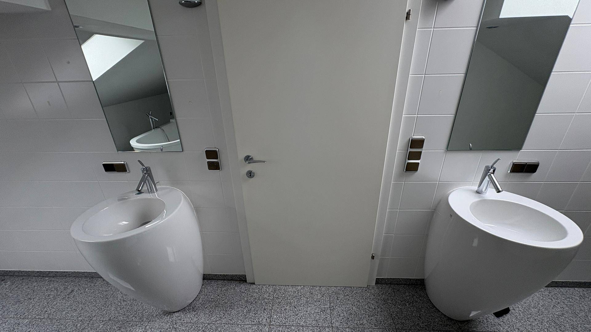 Zwei moderne Waschbecken im Dachgeschossbad mit Spiegeln und minimalistischem Design.