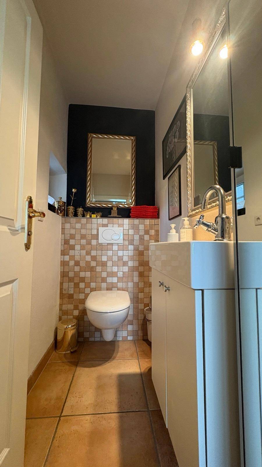 Modernes Gäste-WC mit Wand-WC, Mosaikfliesen und Einzelwaschbecken.