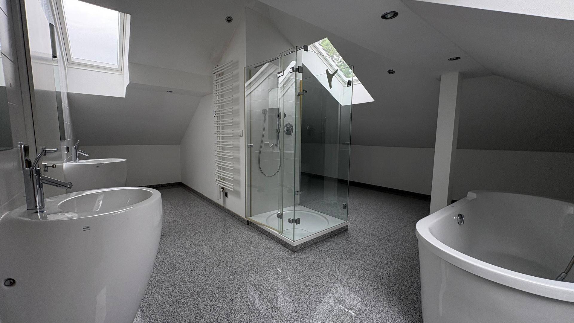 Geräumiges Dachgeschossbad mit Duschkabine, Badewanne und modernen Armaturen.
