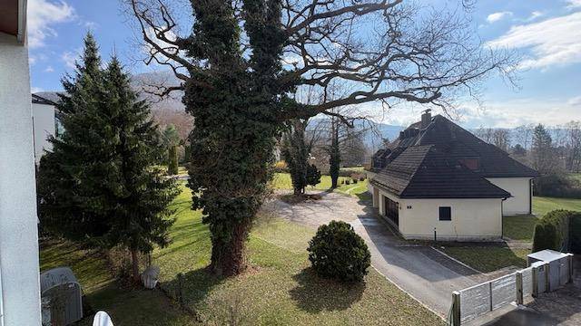 Panoramablick auf ein charmantes Haus mit Satteldach, umgeben von einem gepflegten Garten und alten Bäumen.