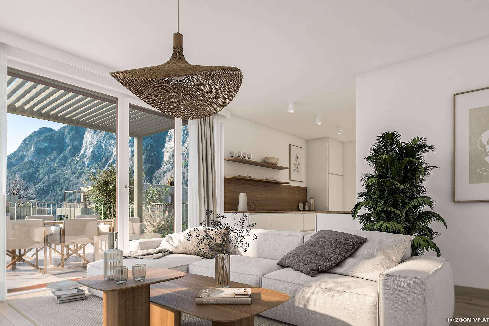 Helles Wohnzimmer mit modernem Sofa, Holztisch und Zugang zu einer großen Terrasse mit Bergblick.