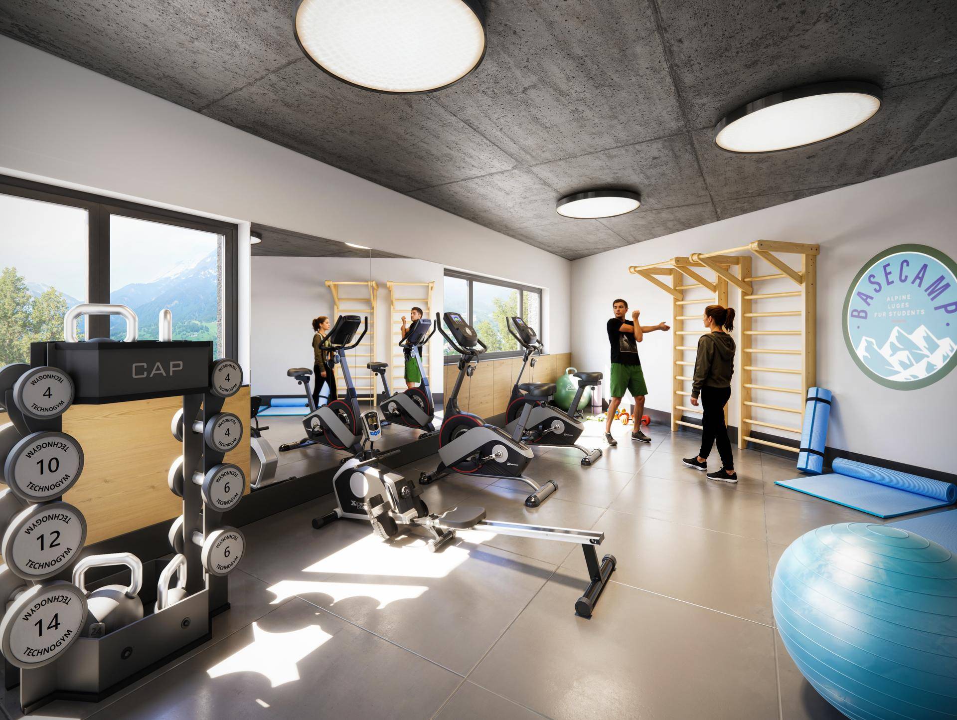 Moderner Fitnessraum mit verschiedenen Trainingsgeräten und großen Fenstern.