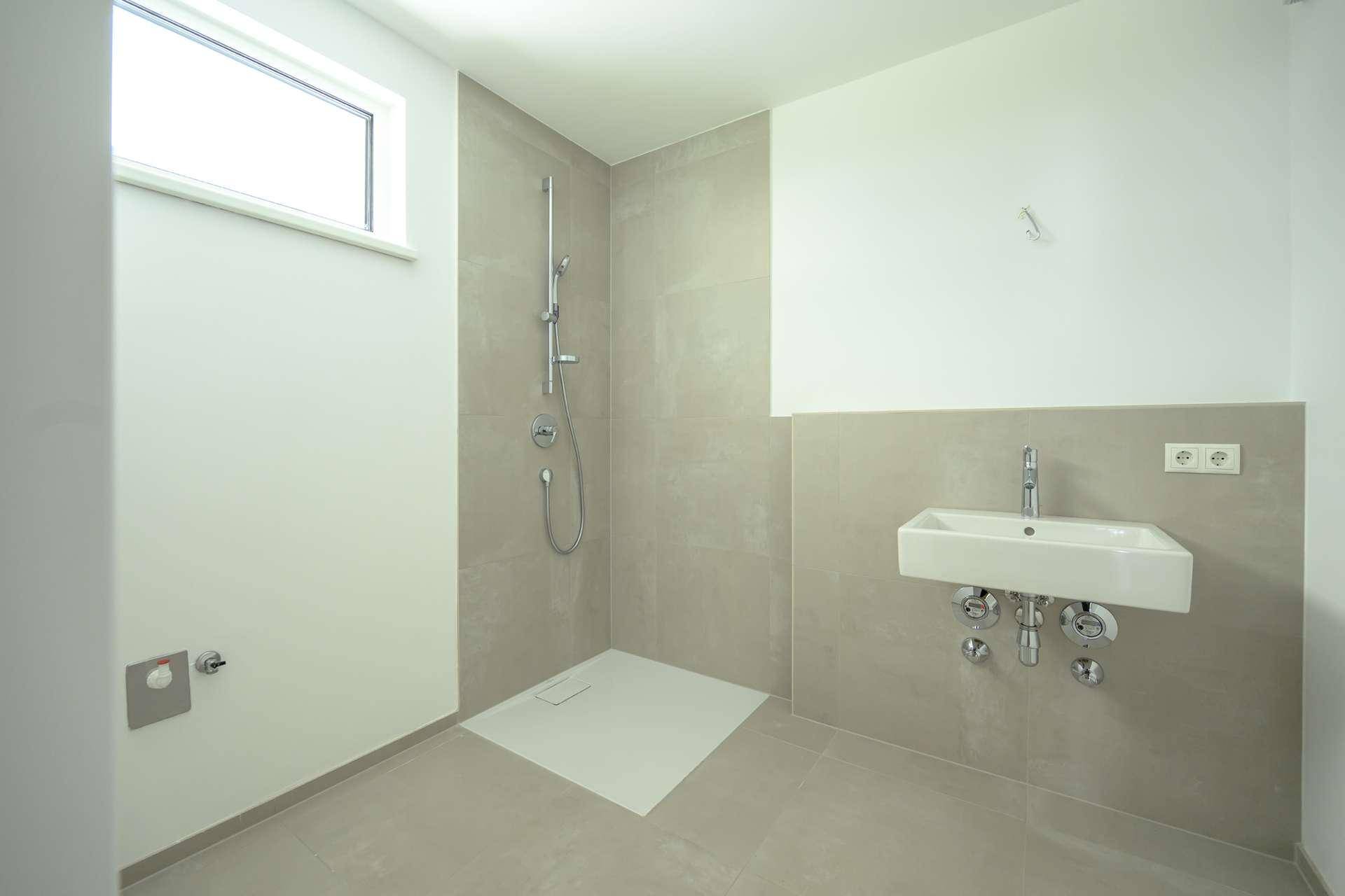 Modernes Badezimmer mit ebenerdiger Dusche, Einzelsink und einem Fenster für Tageslicht.