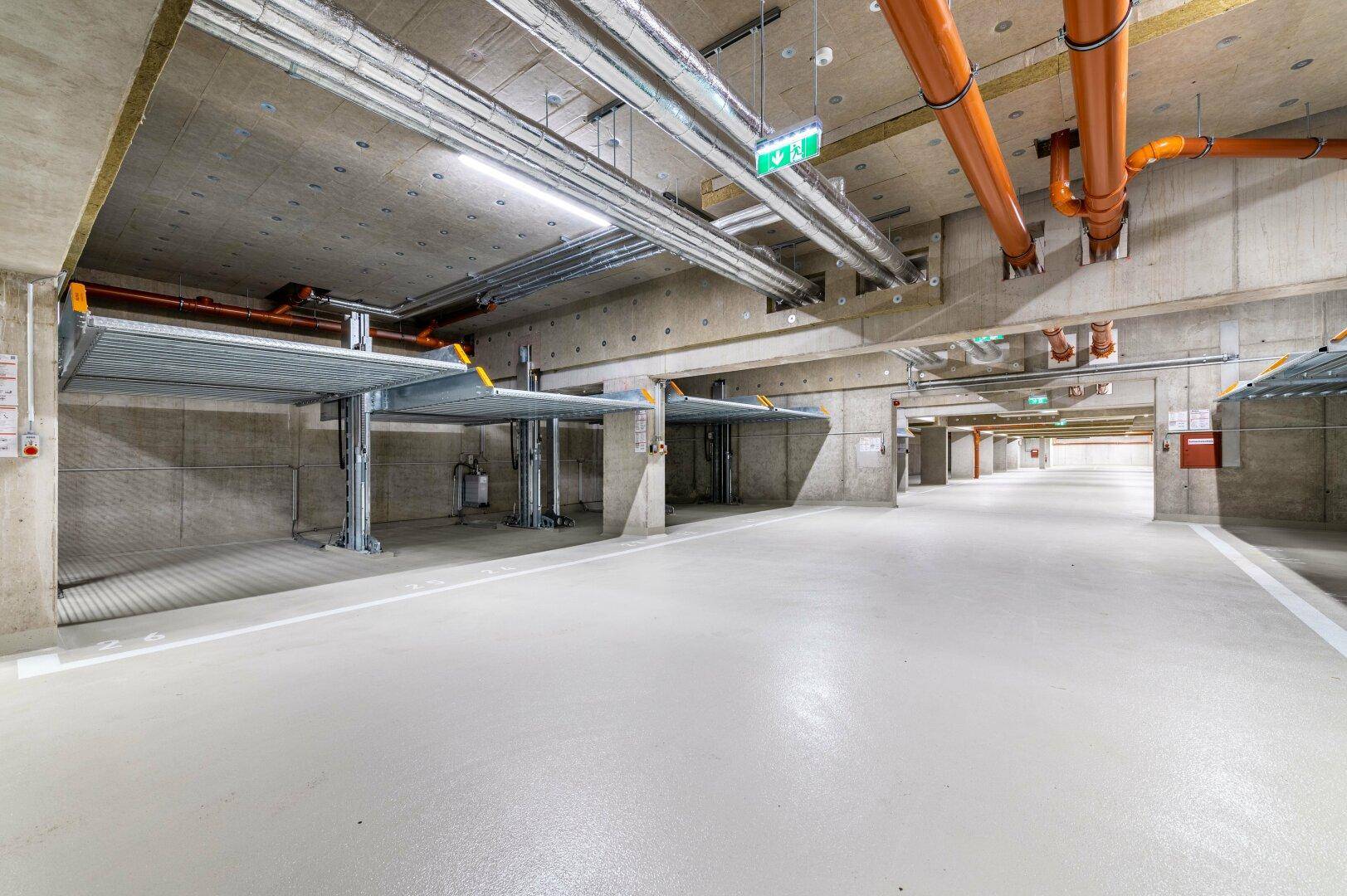 Moderne Tiefgarage mit Doppelparkern für effiziente Raumnutzung und Betonkonstruktion.