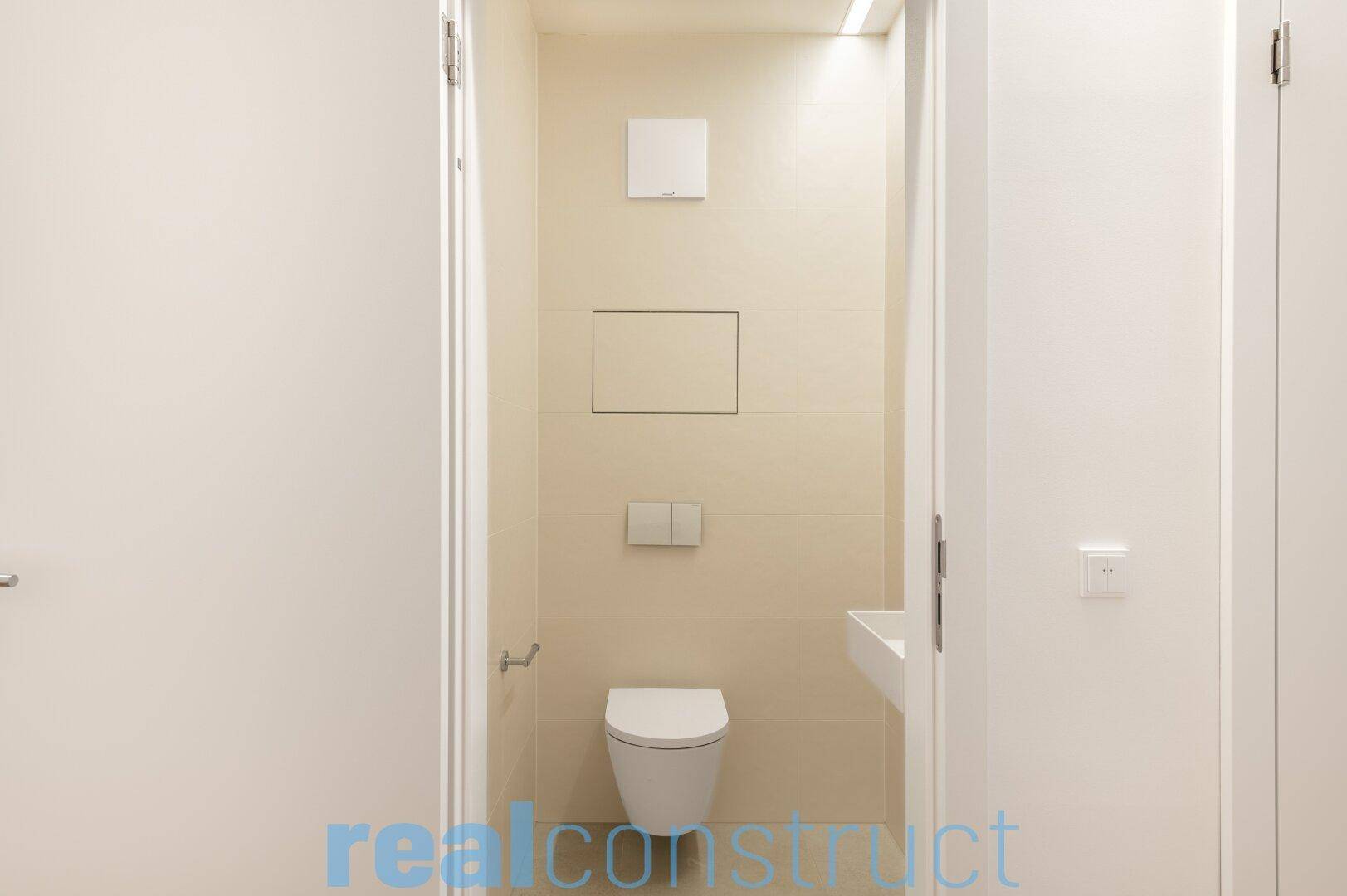 Helles Gäste-WC mit minimalistischem Design und integrierter Lüftung.