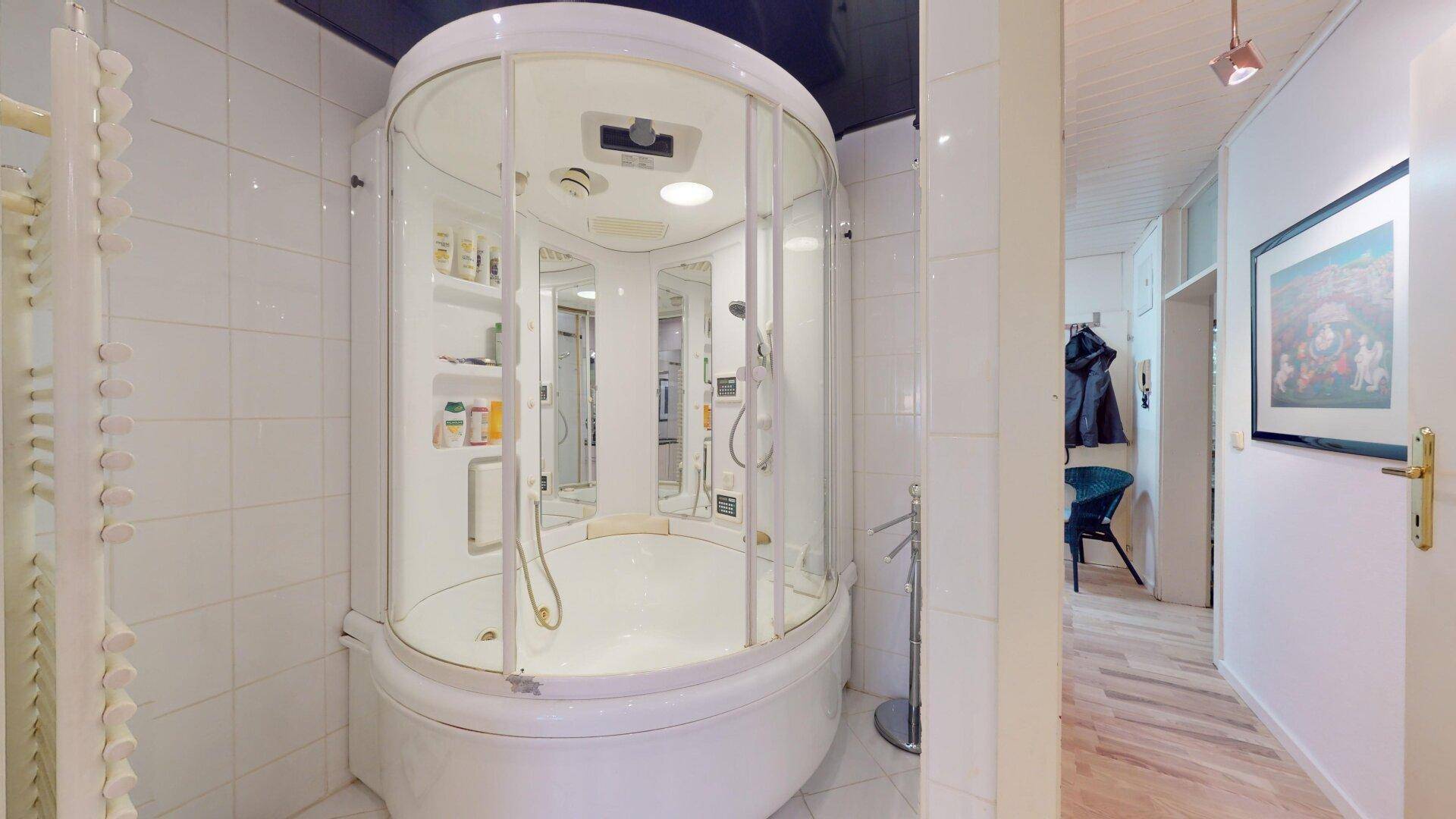 Badezimmer mit moderner Duschkabine und weißen Fliesen, bietet Komfort und Funktionalität.