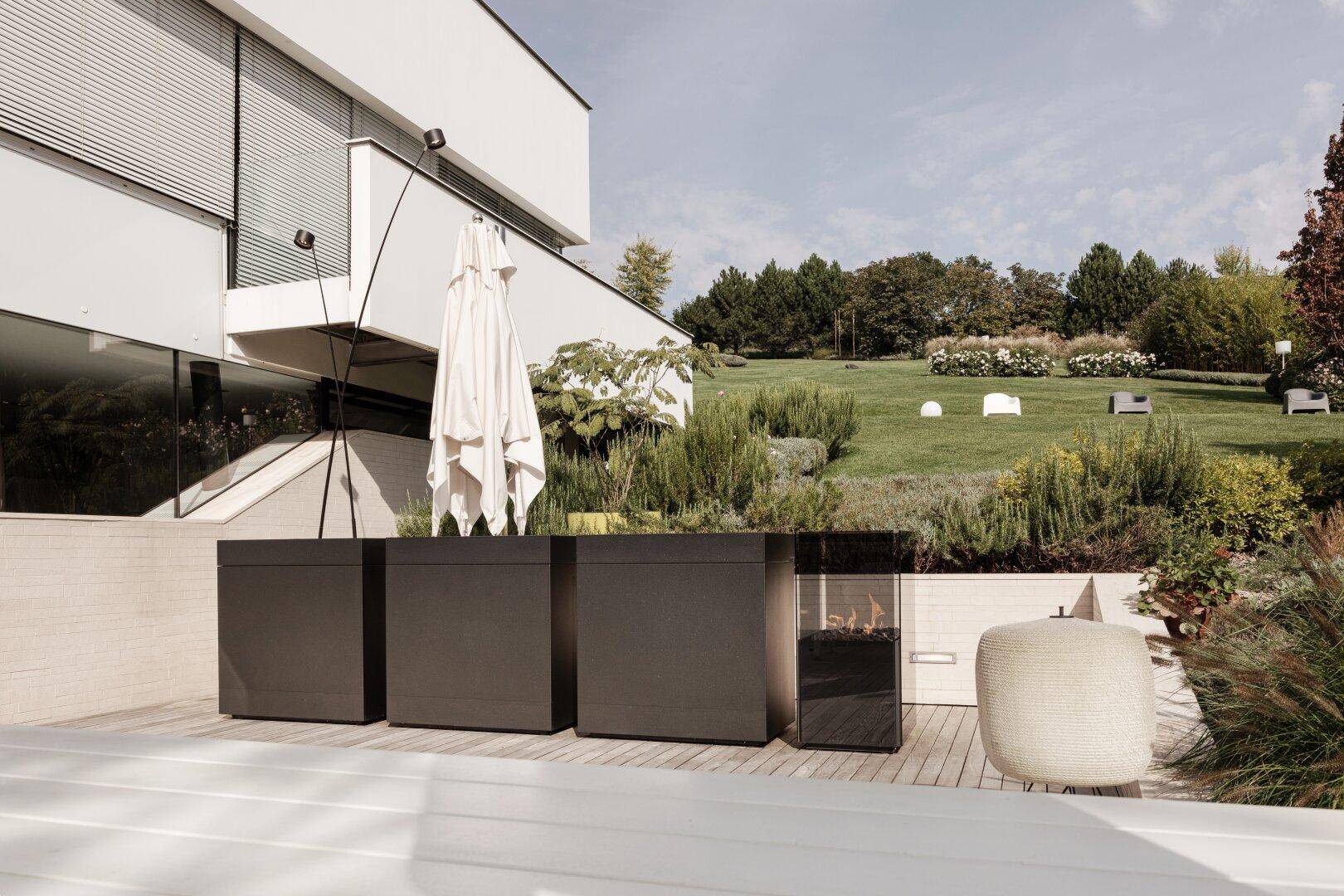Stilvolle Terrasse mit moderner Outdoor-Küche und Blick auf den gepflegten Gartenbereich.