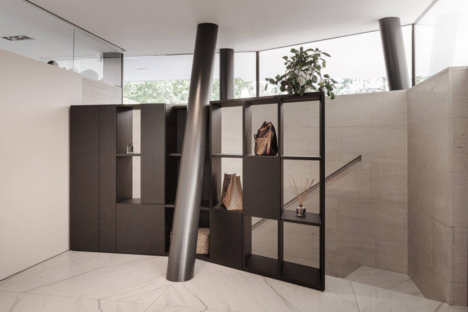 Moderner Eingangsbereich mit Marmorboden, stilvollen Regalen und einer eleganten Treppe.