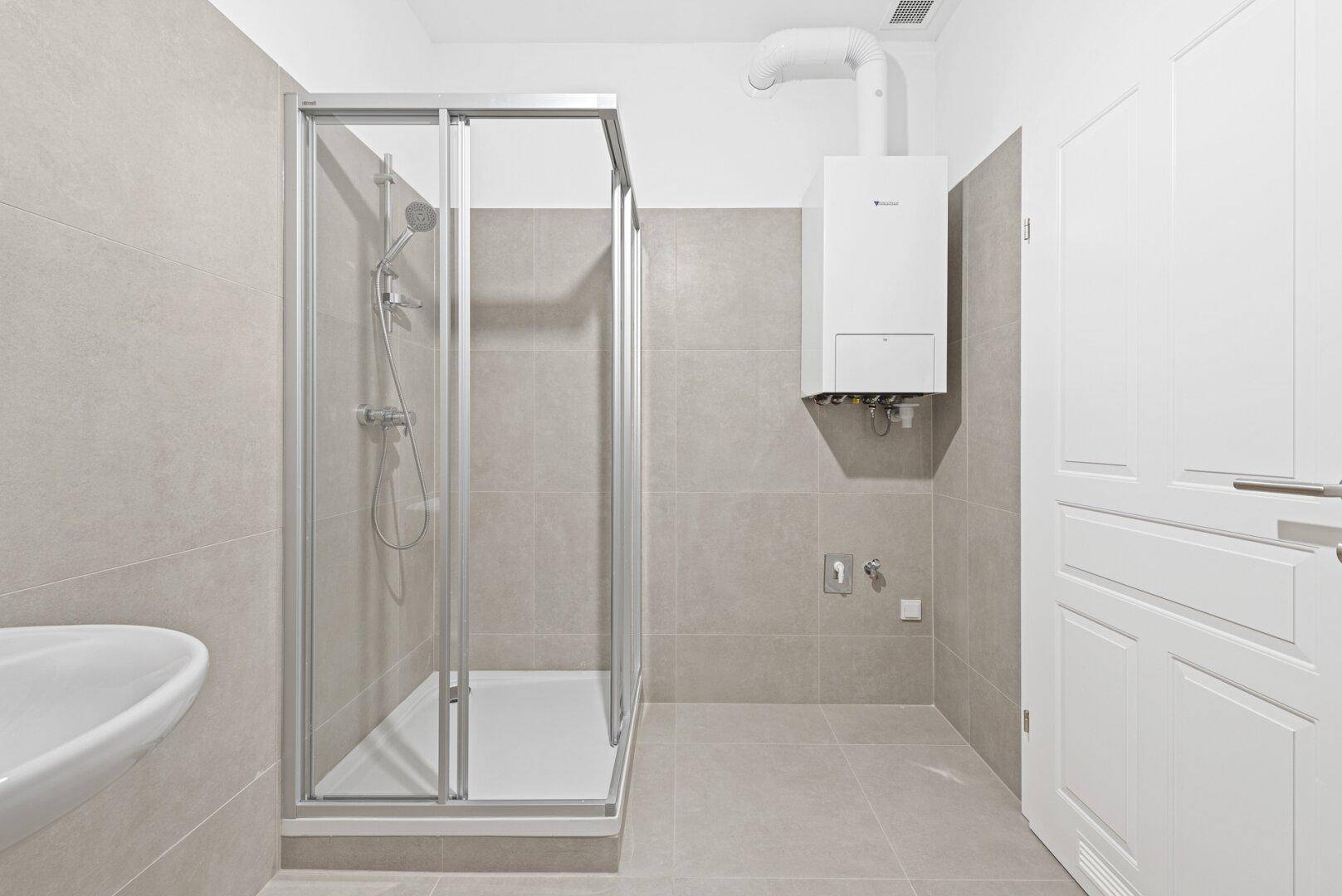 Modernes Badezimmer mit Duschkabine, Waschbecken und Heizungsanlage an der Wand.
