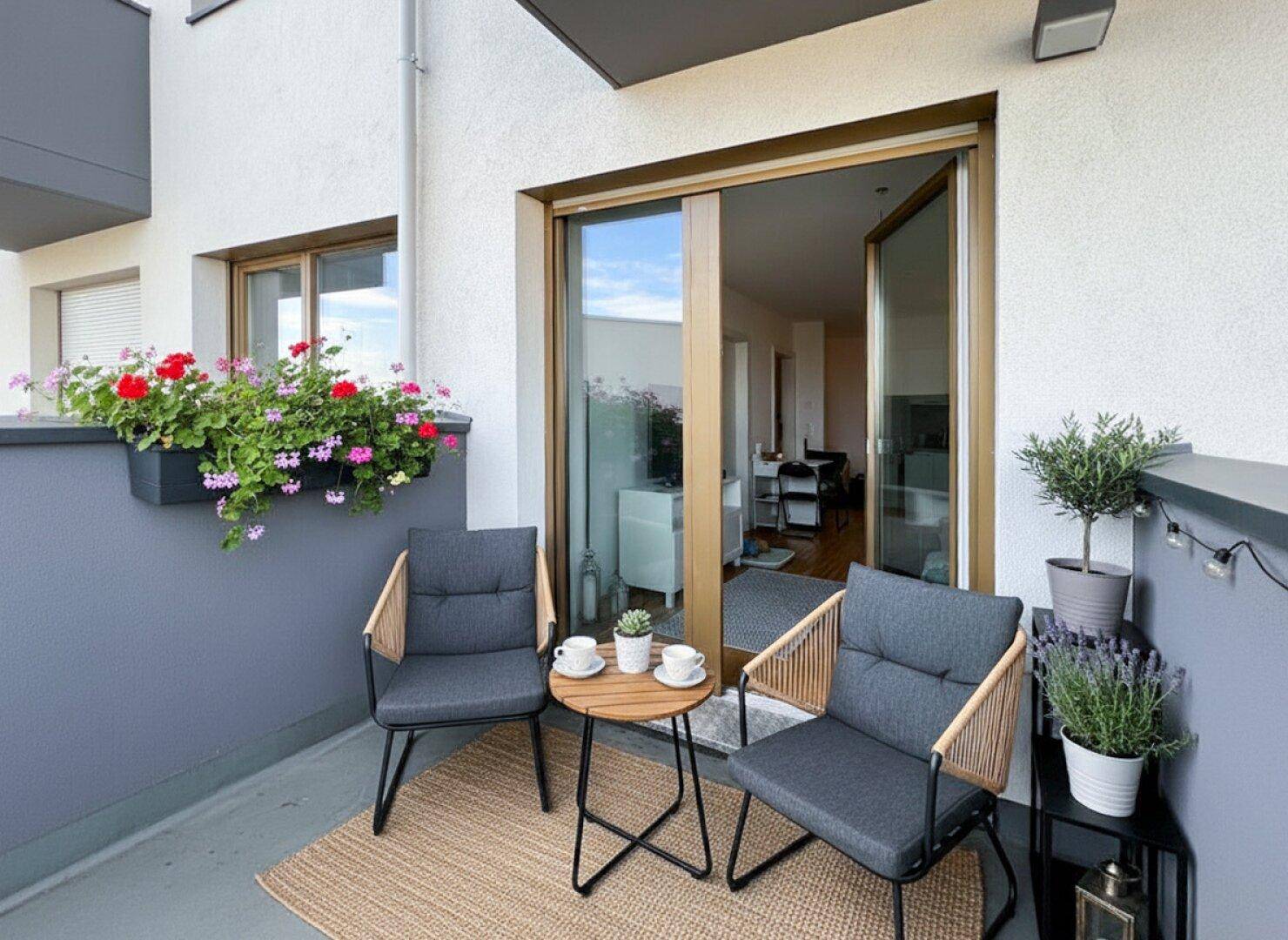 Gemütlicher Balkon mit Sitzgelegenheiten, Pflanzen und Blick auf die Umgebung.
