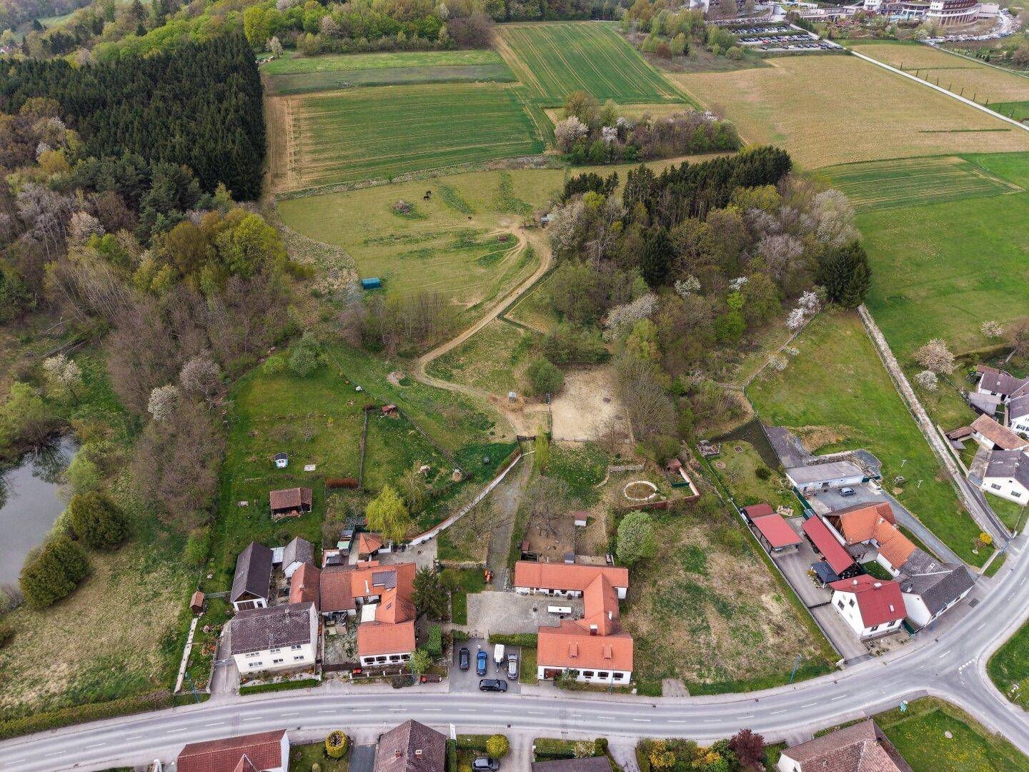 Luftaufnahme des Anwesens in einer grünen, ländlichen Umgebung mit Feldern und Wäldern.