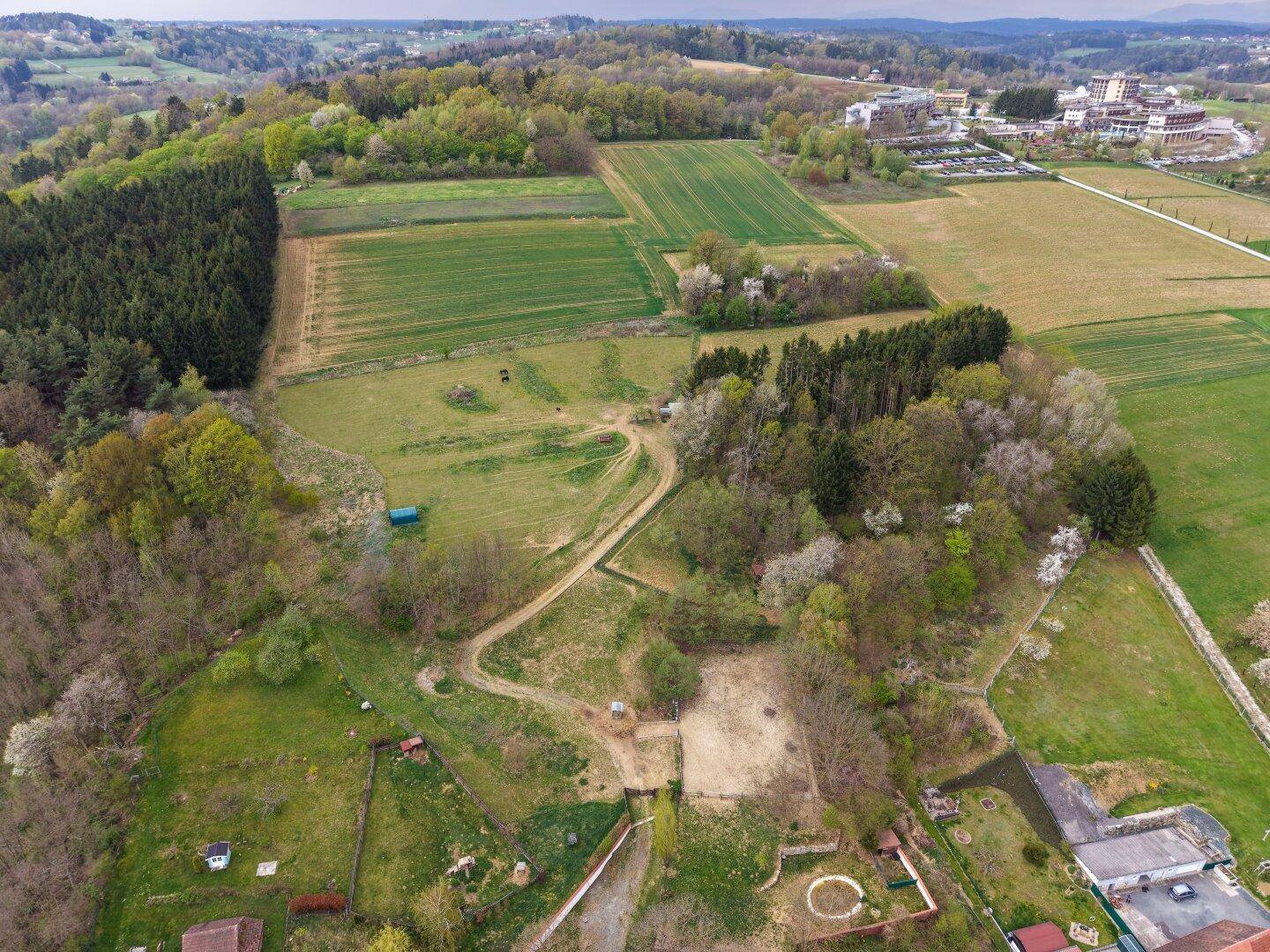 Panoramische Luftaufnahme des Anwesens, umgeben von weiten Feldern und Wäldern.