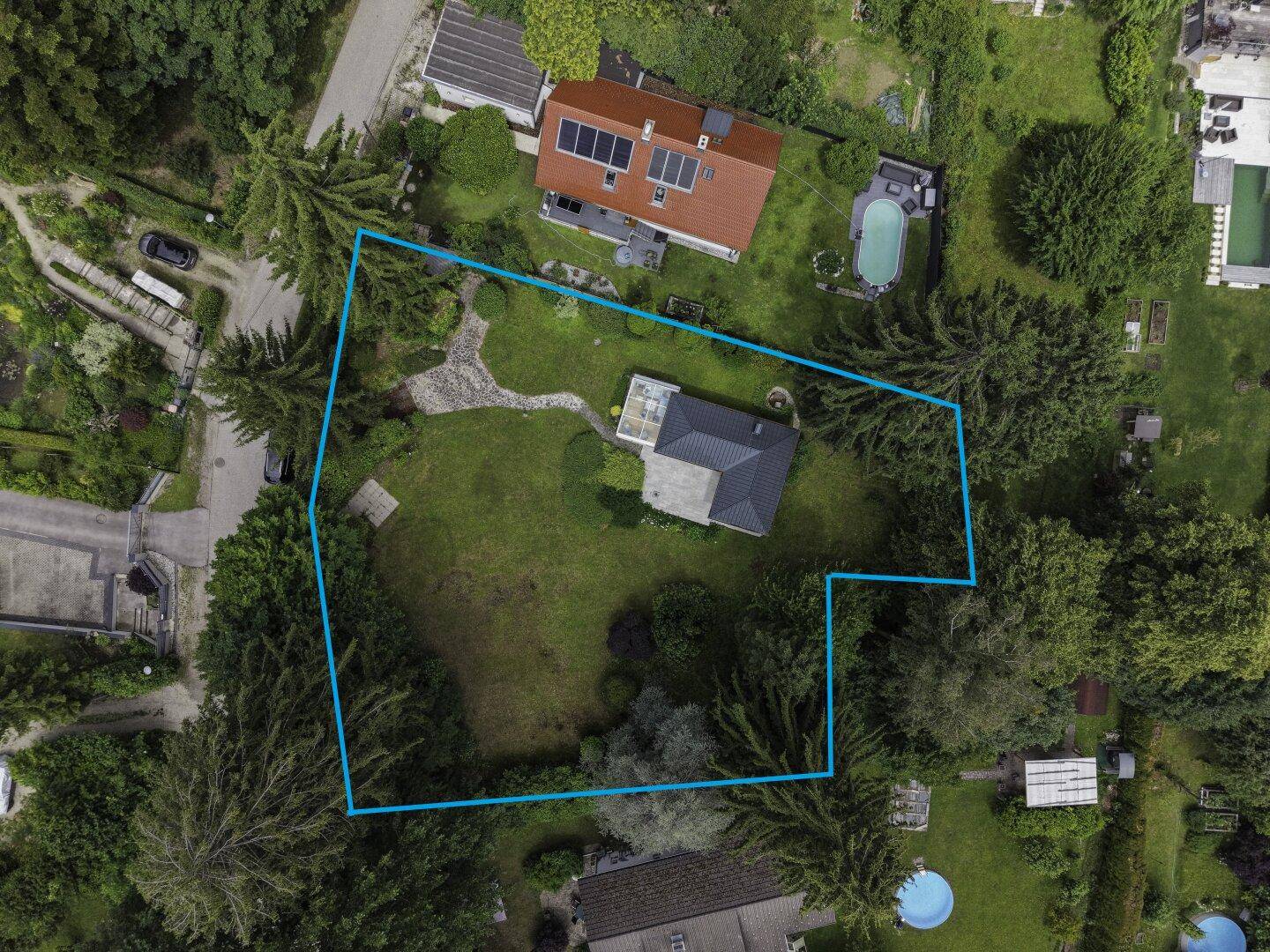 Übersichtliche Luftaufnahme des Anwesens mit großem Garten und angrenzenden Grundstücken.