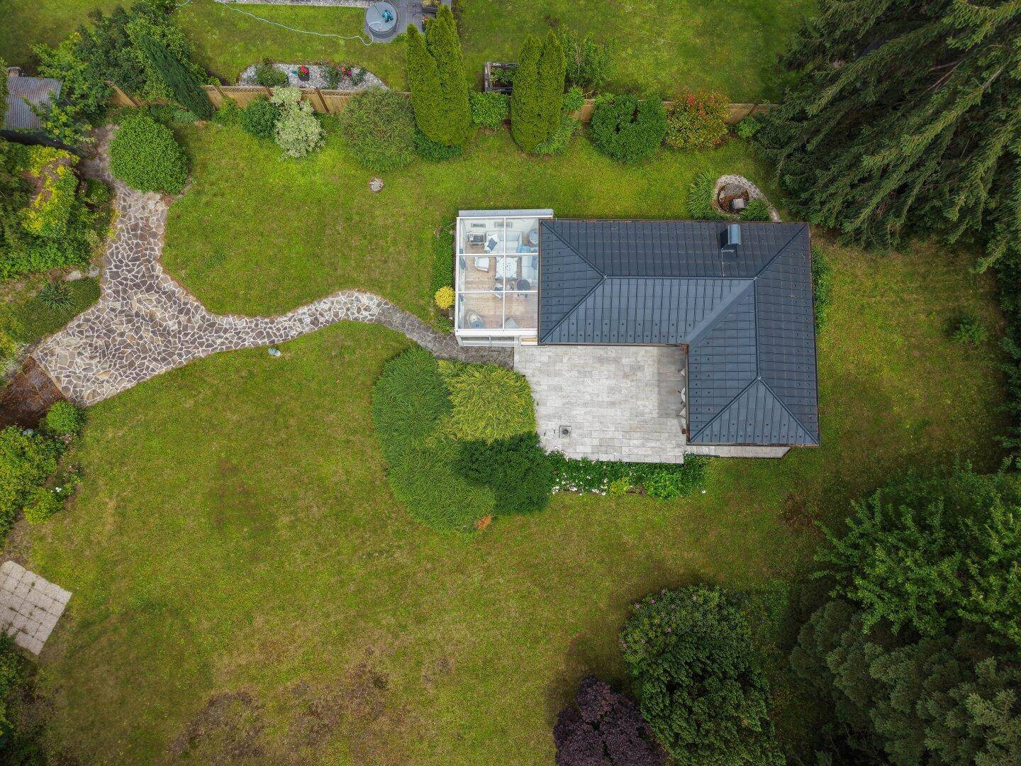 Vogelperspektive des Hauses mit Wintergarten, Terrasse und weitläufigem, gepflegtem Gartenbereich.