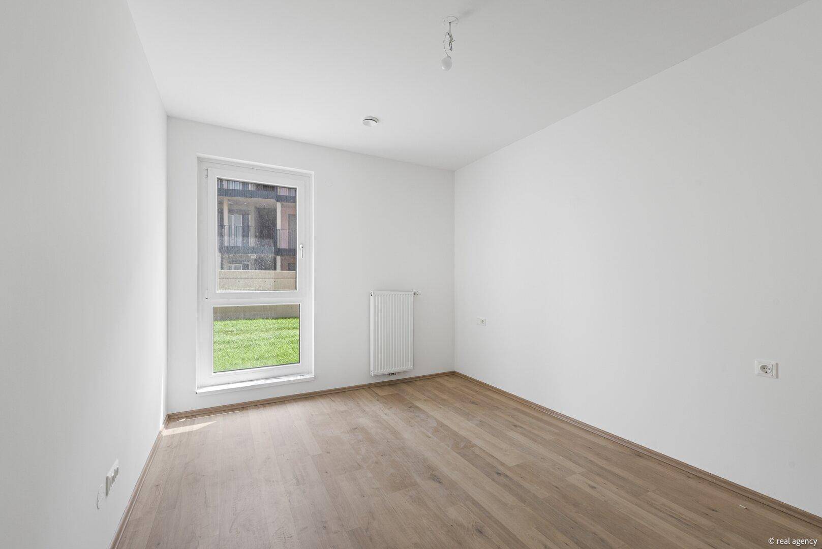 Heller, leerer Raum mit Holzboden und Fenster, ideal als Schlafzimmer oder Arbeitszimmer nutzbar.