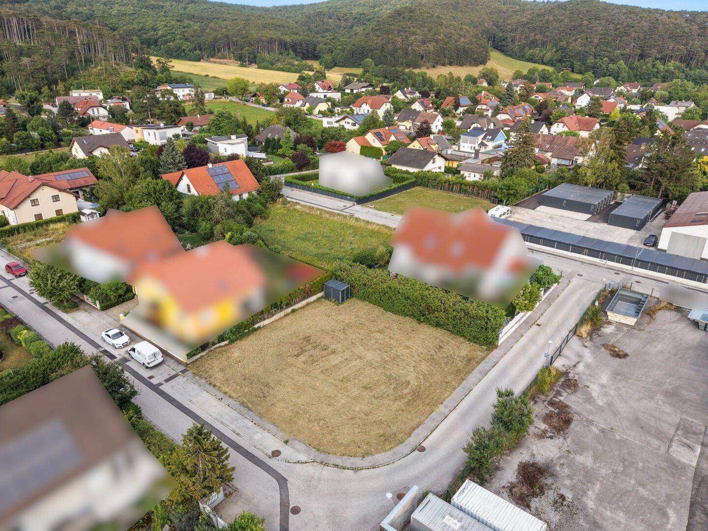 Übersicht aus der Vogelperspektive eines unbebauten Grundstücks, umgeben von Wohn- und Gewerbegebäuden.