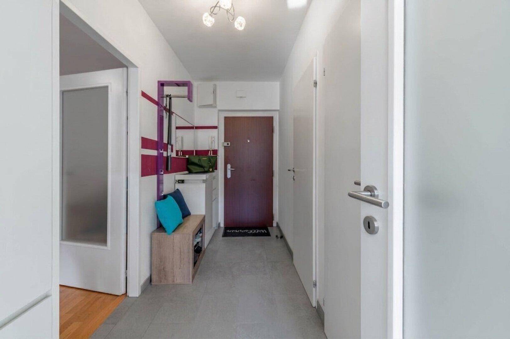 Eingangsbereich mit Fliesenboden, Garderobe und Zugang zu weiteren Zimmern.