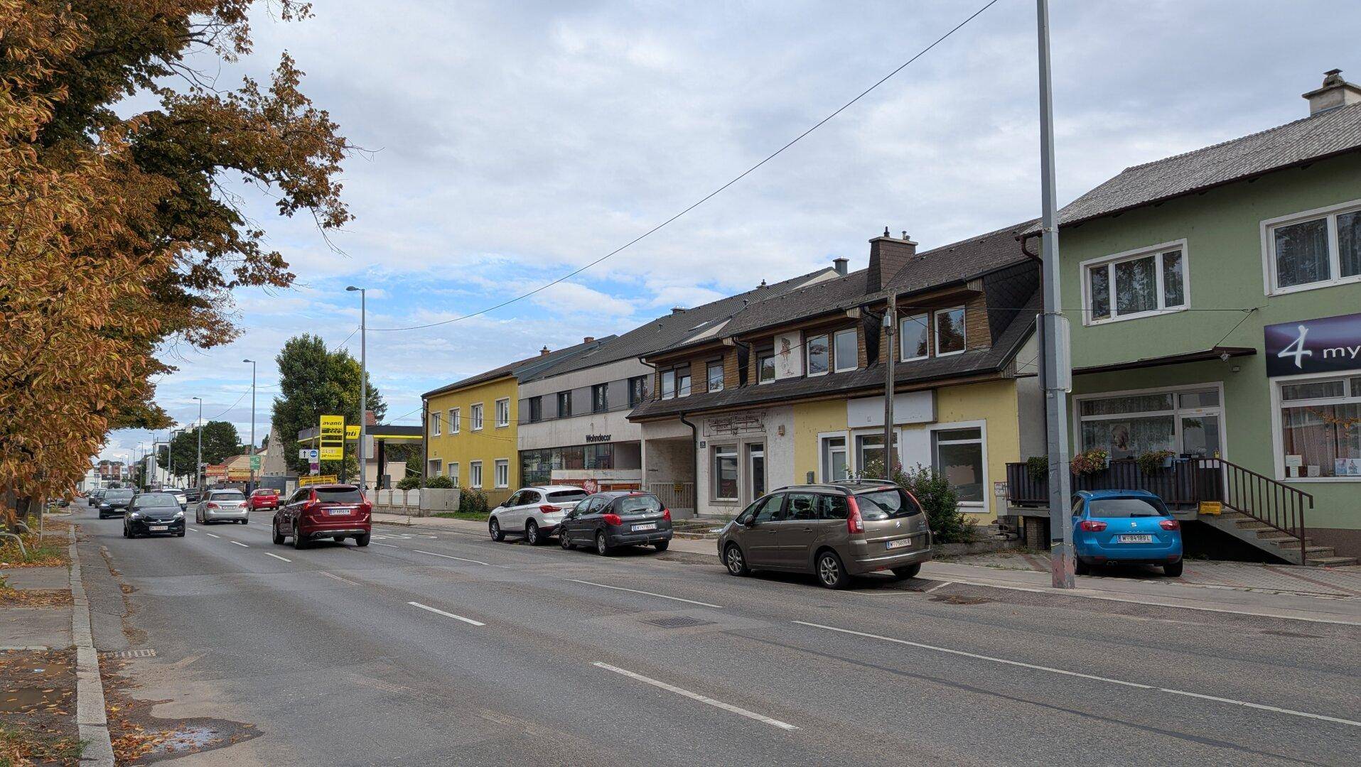 Weitläufige Straßenansicht mit verschiedenen Gebäuden und parkenden Autos, die die Umgebung des Objekts zeigt.