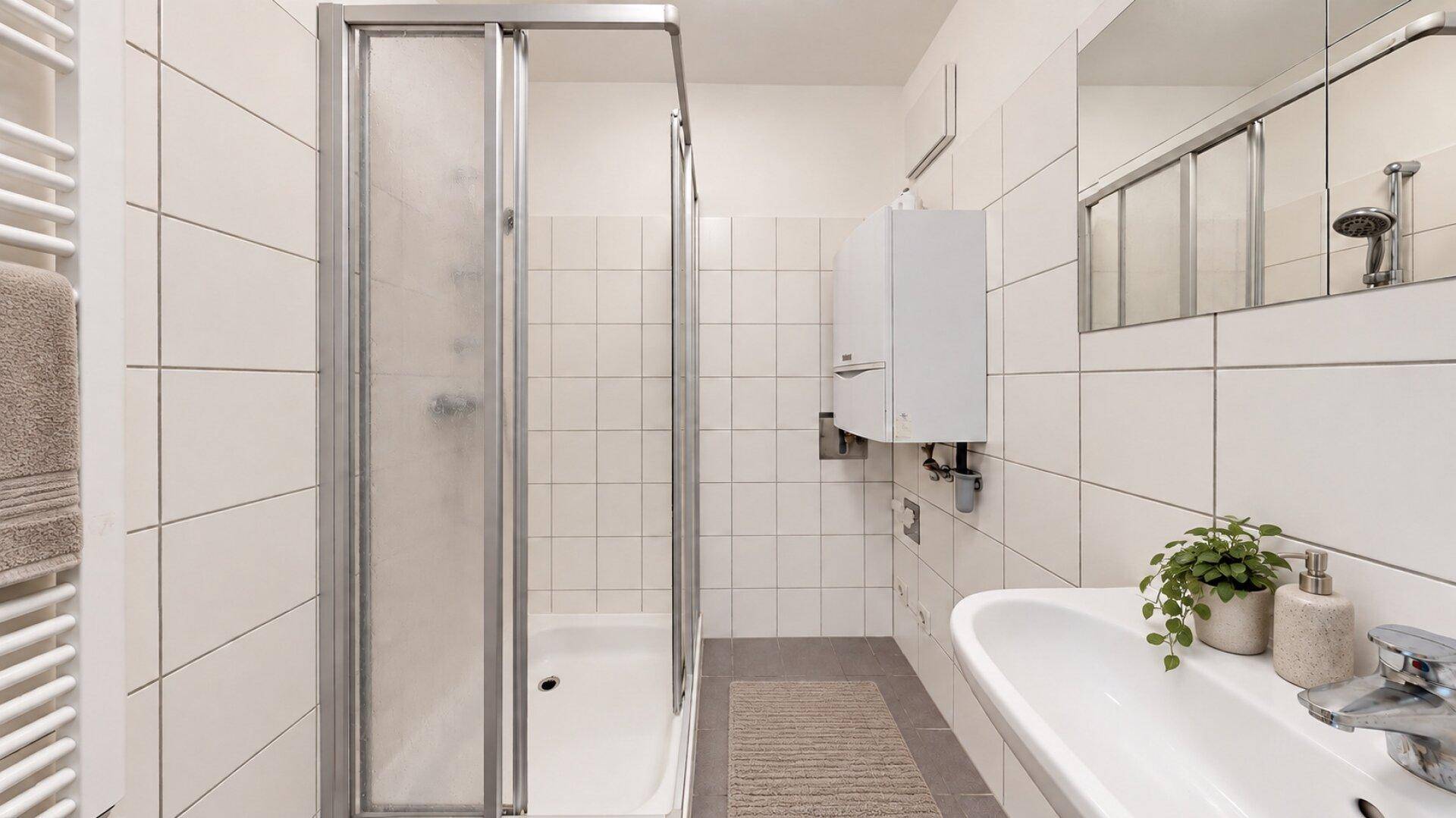 Funktionales Badezimmer mit Duschkabine, Waschbecken und weißen Wandfliesen.