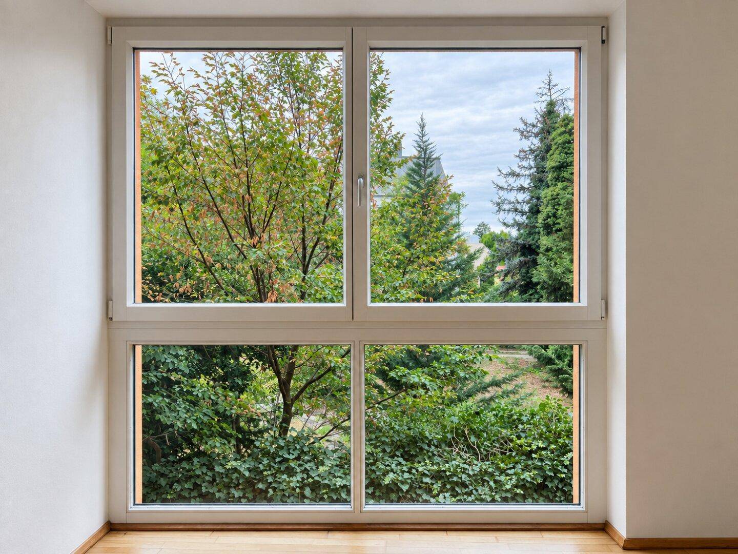 Großes Fenster mit weitem Blick ins Grüne, das viel natürliches Tageslicht hereinlässt.