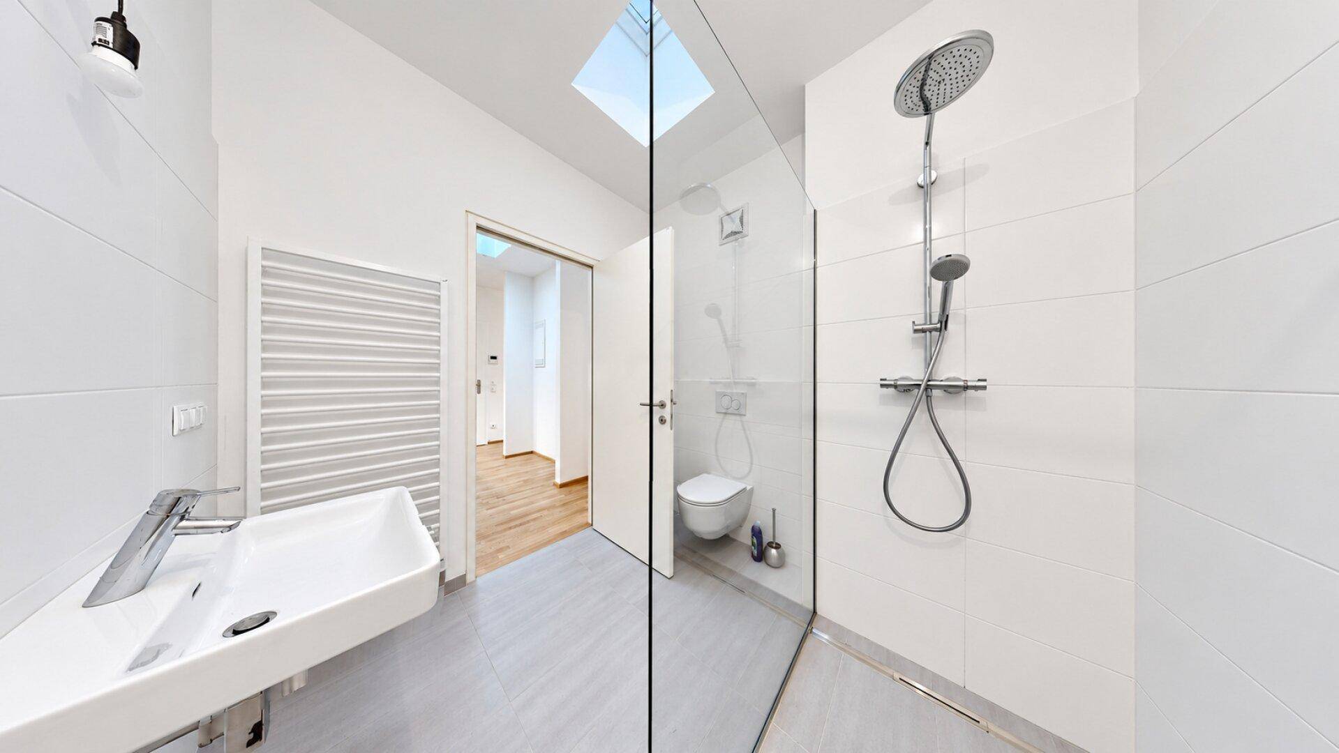 Modernes Badezimmer mit begehbarer Dusche, Einzelwaschbecken und beheiztem Handtuchhalter.