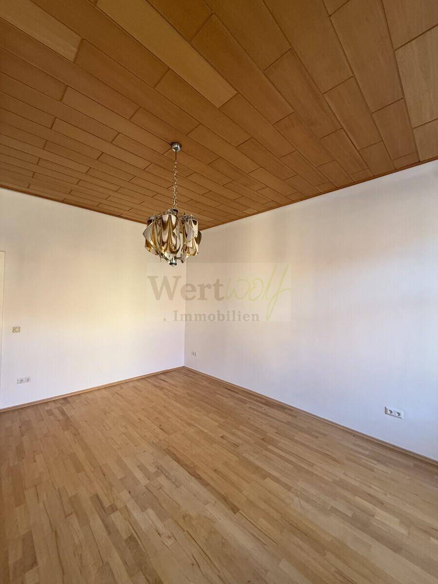 Geräumiges Zimmer mit Holzdecke und Parkettboden, bereit für individuelle Gestaltung und Nutzung als Wohnraum.