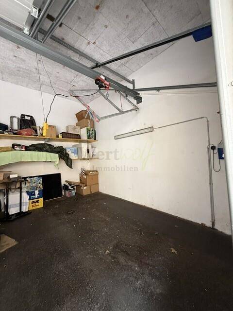 Innenansicht einer Garage mit Stauraum und sichtbarer Deckenkonstruktion.