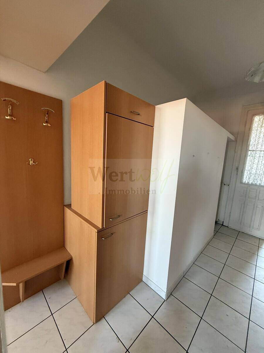 Eingangsbereich mit praktischen Holzschränken und Garderobe, ideal für Stauraum.