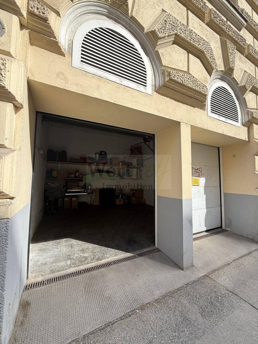 Außenansicht eines Gebäudes mit offener Garageneinfahrt und dekorativer Fassade.