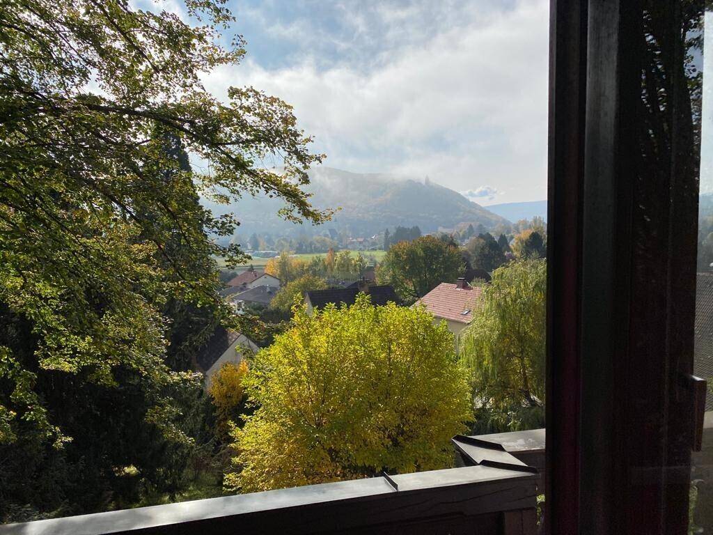 Panoramablick von einem Balkon auf die umliegende Landschaft mit Häusern und Bergen.