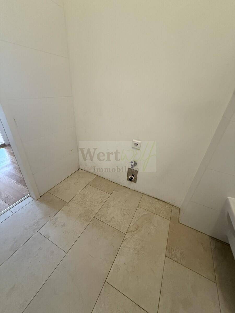 Praktischer Bereich im Badezimmer mit Anschlüssen für eine Waschmaschine, ideal für den Hauswirtschaftsbereich.