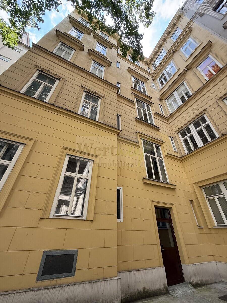 Innenhoffassade des Gebäudes mit vielen Fenstern und gelber Farbgebung.