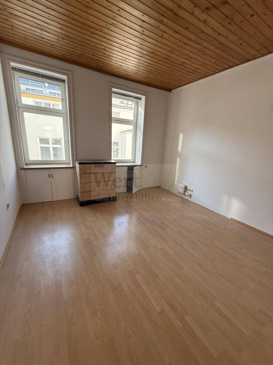 Heller Raum mit Parkettboden und Holzdecke, ideal für Wohn- oder Schlafzimmernutzung, mit viel Tageslicht.