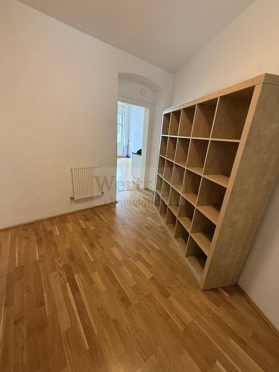 Flur mit großem Holzregal für Bücher oder Dekoration, bietet vielseitige Nutzungsmöglichkeiten.
