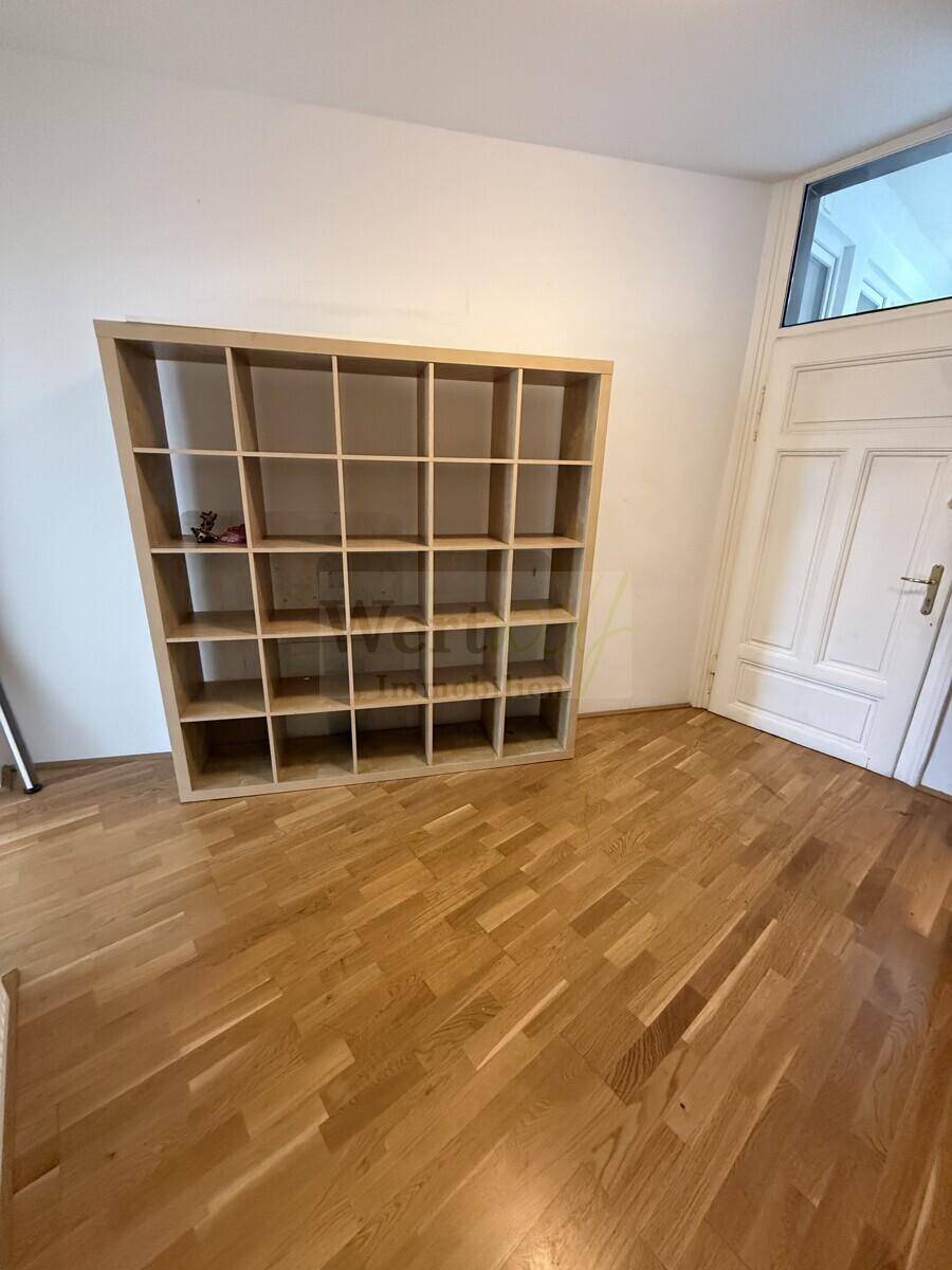 Geräumiger Flur mit großem Regal und Eingangstür, bietet viel Platz für individuelle Gestaltung.