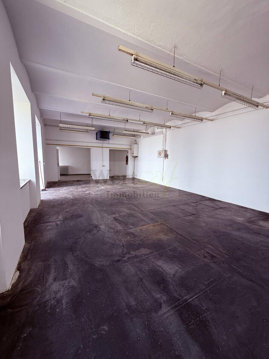 Weitläufiger, heller Raum mit industriellem Charme und hohen Decken, ideal für Loft-Wohnen.