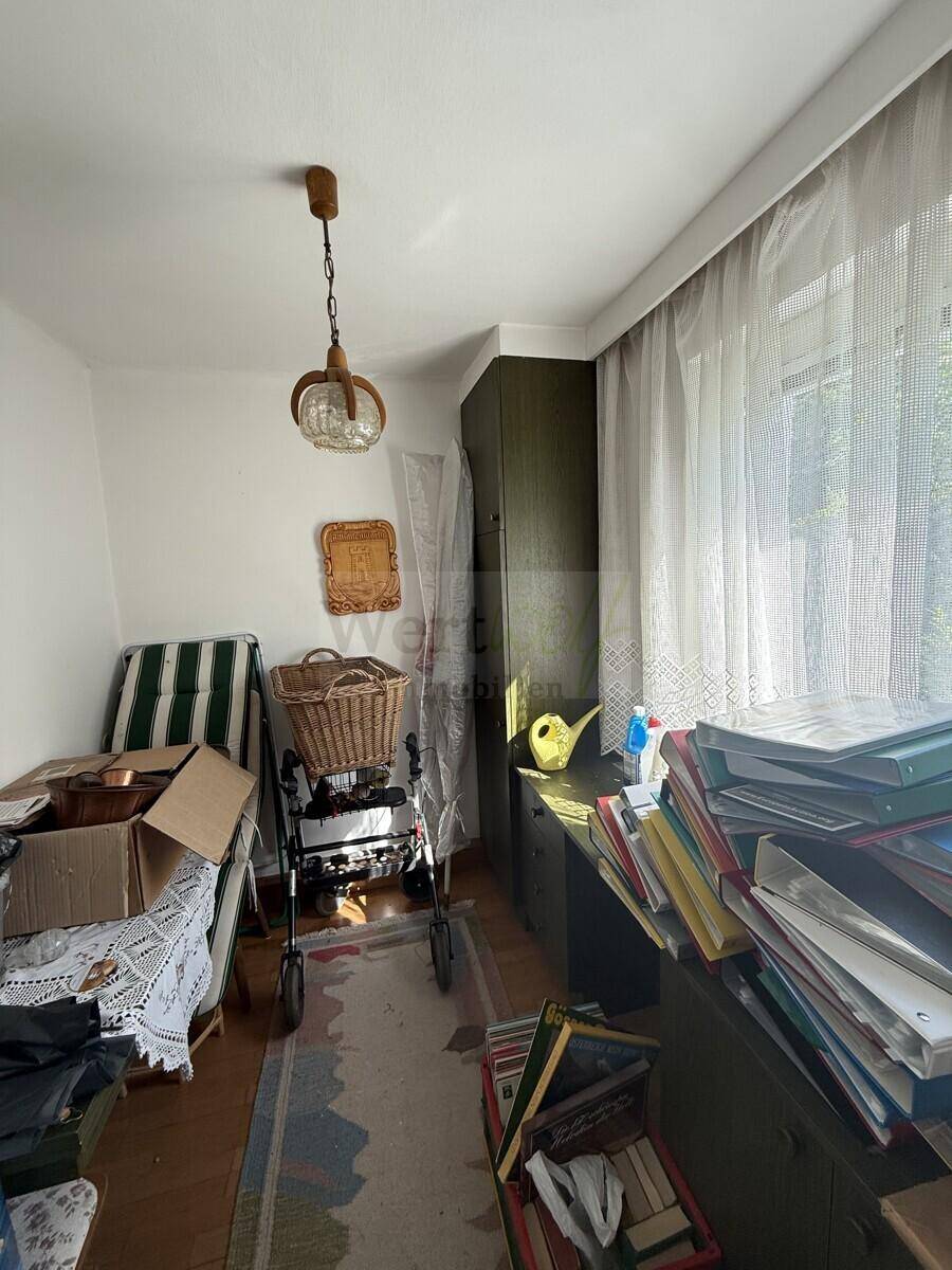 Helles Zimmer mit Fenster, das als Büro oder Abstellraum genutzt werden könnte, mit viel Stauraum.