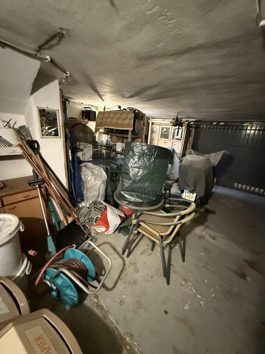 Geräumige Garage im Keller mit viel Stauraum und einem Garagentor.