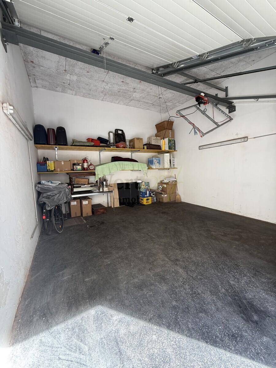 Geräumige Garage mit Stauraum, Regalen und einem Fahrrad.