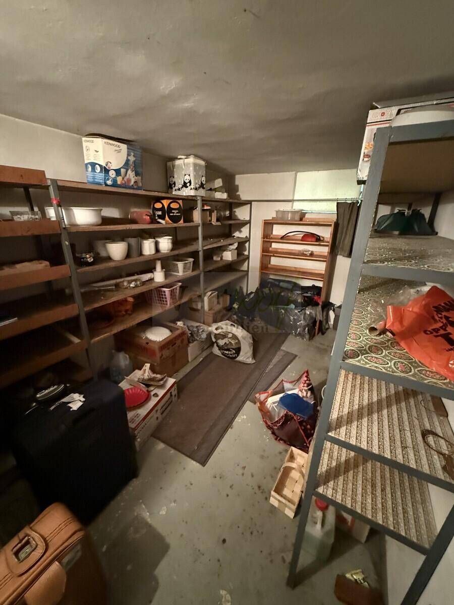 Kellerraum mit Regalen und verschiedenen gelagerten Gegenständen, ideal als Vorratsraum.